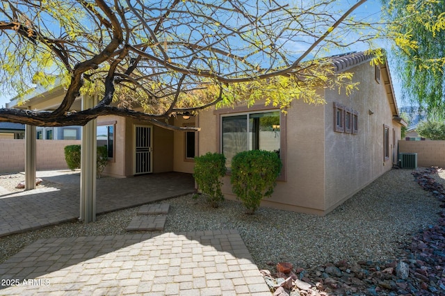 back of property featuring a patio, central air condition unit, fence, and stucco siding