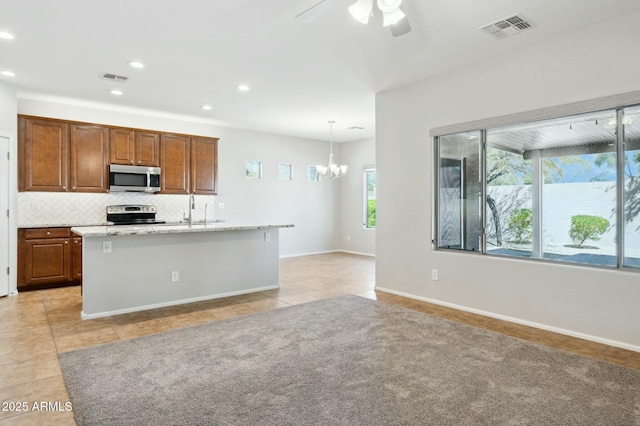 kitchen with an island with sink, visible vents, stainless steel appliances, and backsplash