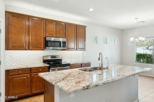 kitchen featuring stainless steel appliances, a sink, visible vents, light stone countertops, and tasteful backsplash