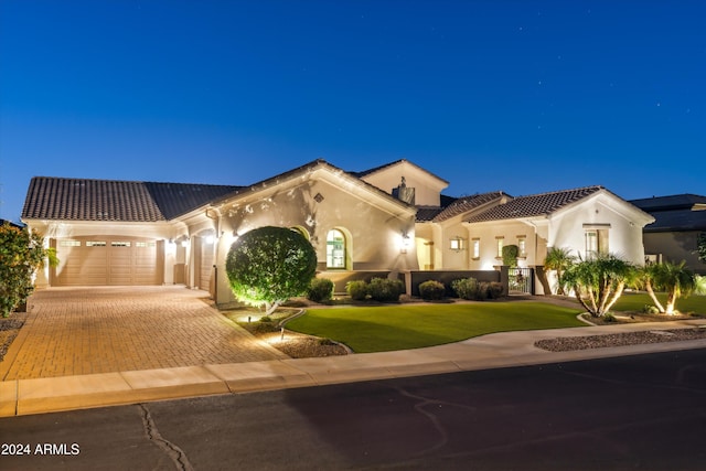 mediterranean / spanish house featuring a garage and a front yard