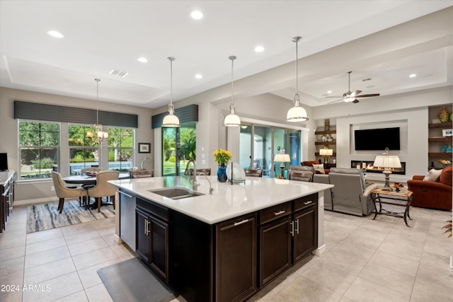 kitchen with sink, a tray ceiling, decorative light fixtures, and dishwasher