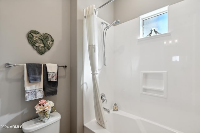 bathroom with toilet and shower / bathtub combination with curtain