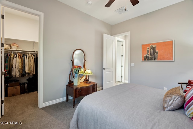 bedroom with a spacious closet, carpet floors, a closet, and ceiling fan