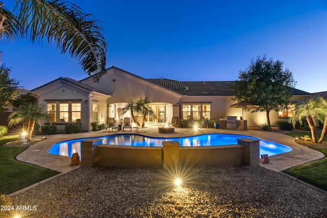 pool at dusk with a patio