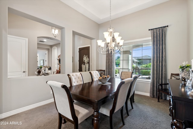 dining room featuring an inviting chandelier and dark colored carpet