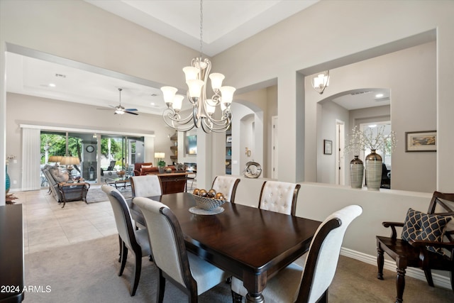 dining area with ceiling fan with notable chandelier and light tile patterned flooring