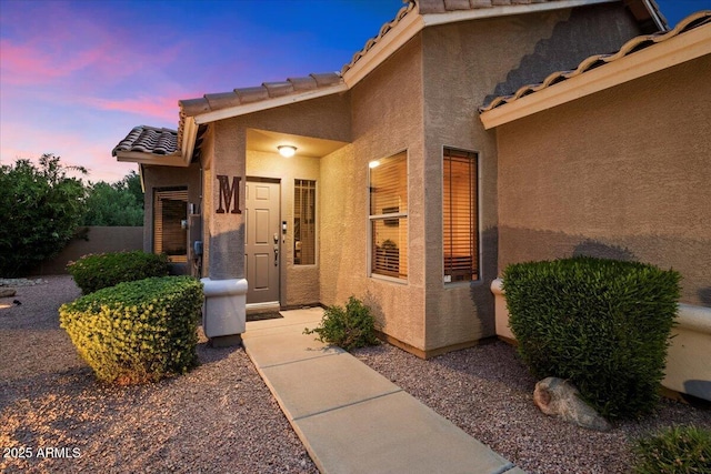 7471 E Desert Vista Rd, Scottsdale, AZ 85255 - exterior entry at dusk with stucco siding and a tiled roof
