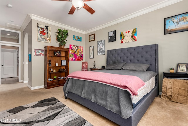 carpeted bedroom featuring ceiling fan and crown molding