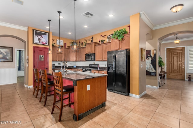 kitchen featuring crown molding, pendant lighting, an island with sink, and black appliances