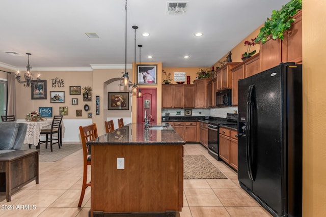 kitchen featuring pendant lighting, a kitchen island with sink, black appliances, crown molding, and a breakfast bar area