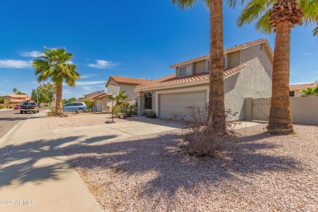 mediterranean / spanish home with a tiled roof, stucco siding, driveway, and a garage