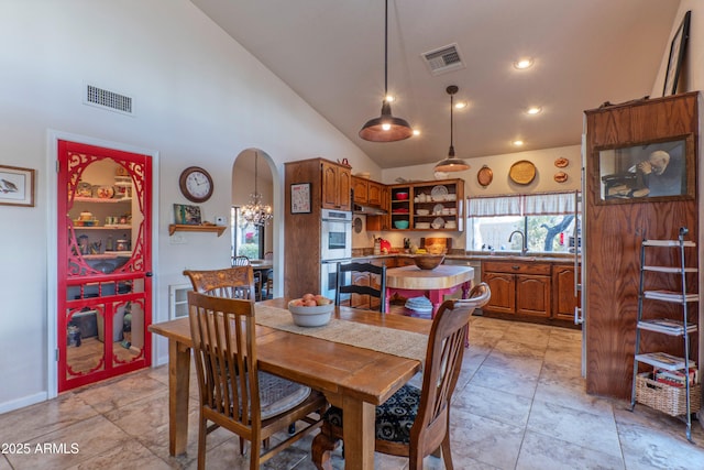 dining area with sink and high vaulted ceiling