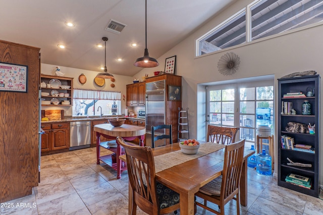 dining space with high vaulted ceiling, plenty of natural light, and sink