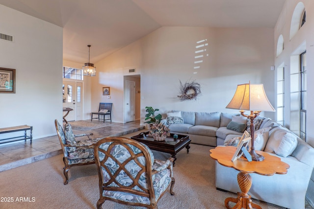 carpeted living room featuring high vaulted ceiling