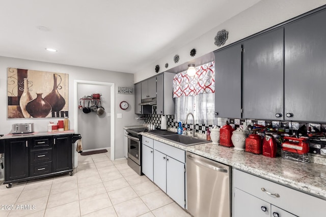 711 E Laurel Dr Unit 17, Casa Grande, AZ 85122 - kitchen featuring light tile patterned floors, a sink, decorative backsplash, under cabinet range hood, and appliances with stainless steel finishes