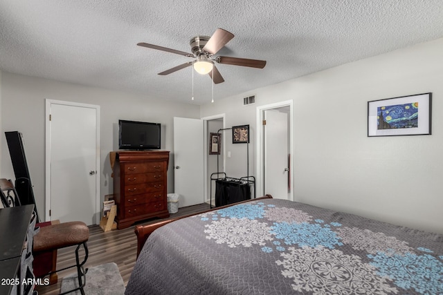 711 E Laurel Dr Unit 17, Casa Grande, AZ 85122 - bedroom with visible vents, a textured ceiling, ceiling fan, and wood finished floors