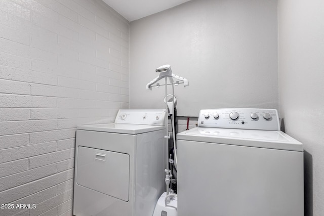 711 E Laurel Dr Unit 17, Casa Grande, AZ 85122 - washroom featuring laundry area, brick wall, and washing machine and clothes dryer