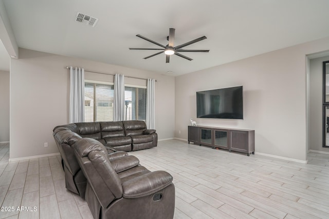 living room with ceiling fan and light hardwood / wood-style flooring