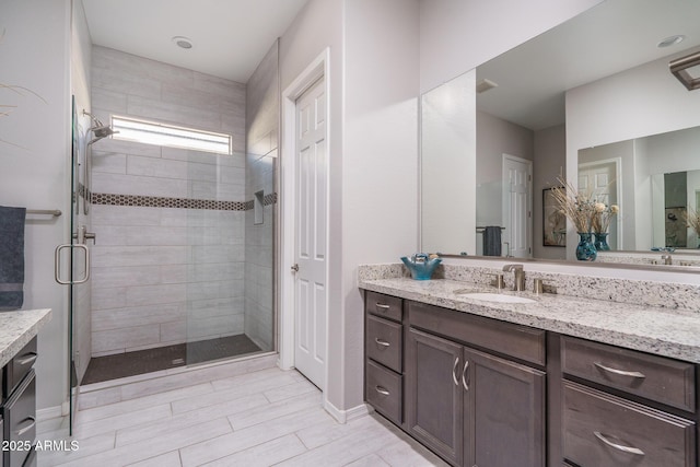 bathroom featuring vanity and a shower with shower door