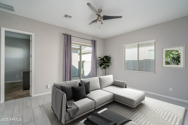 living room with ceiling fan, light hardwood / wood-style floors, and a wealth of natural light