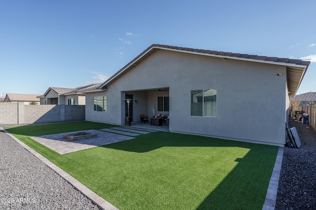 rear view of house featuring an outdoor fire pit, a patio, and a lawn