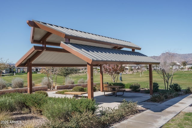 view of community featuring a gazebo, a mountain view, a lawn, and a patio area