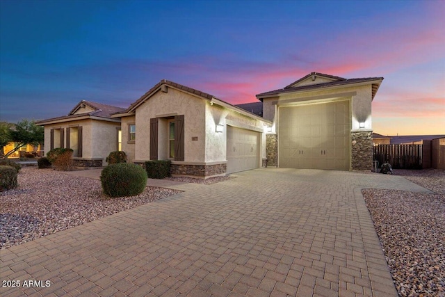 18577 W Coolidge St, Goodyear, AZ 85395 - ranch-style home featuring stone siding, a garage, driveway, and stucco siding