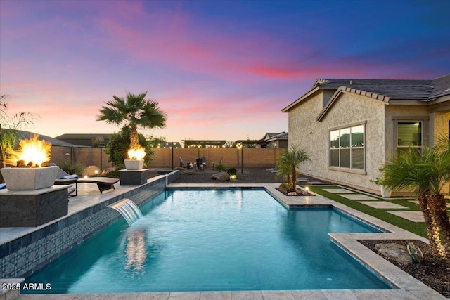 18577 W Coolidge St, Goodyear, AZ 85395 - pool at dusk featuring a fenced backyard, a fire pit, and a patio