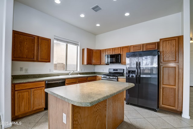 kitchen with visible vents, black appliances, a sink, a kitchen island, and light tile patterned flooring