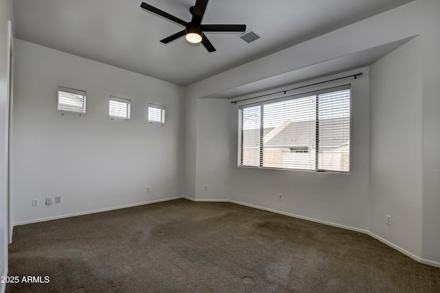 unfurnished room with baseboards, visible vents, dark colored carpet, and ceiling fan