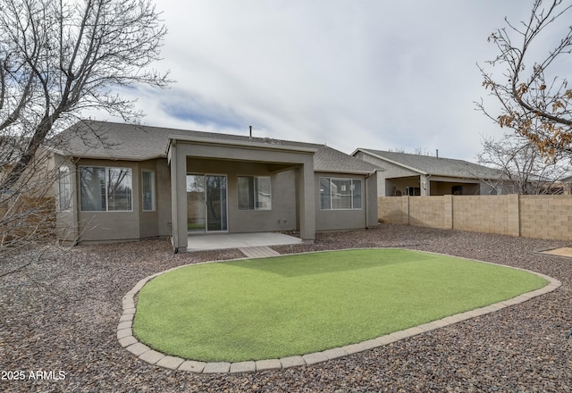 rear view of property with stucco siding, a shingled roof, a patio, and fence