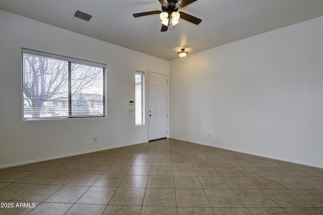 spare room featuring light tile patterned flooring, baseboards, and visible vents