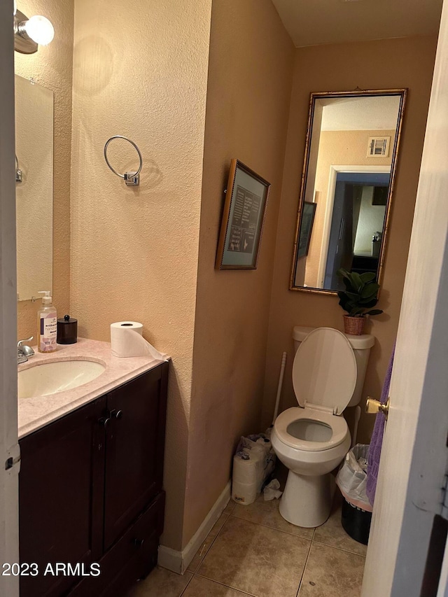 bathroom featuring vanity, tile floors, and toilet