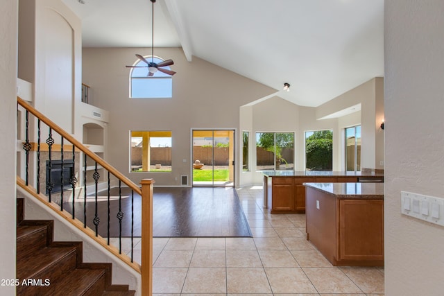 7421 S 25th Ln, Phoenix, AZ 85041 - kitchen featuring ceiling fan, beam ceiling, plenty of natural light, high vaulted ceiling, and brown cabinets