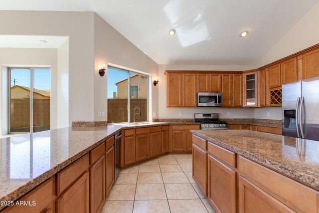 7421 S 25th Ln, Phoenix, AZ 85041 - kitchen featuring stainless steel appliances, vaulted ceiling, a sink, brown cabinets, and recessed lighting