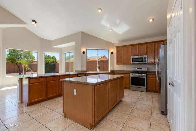 7421 S 25th Ln, Phoenix, AZ 85041 - kitchen featuring appliances with stainless steel finishes, light tile patterned flooring, brown cabinetry, dark stone countertops, and recessed lighting