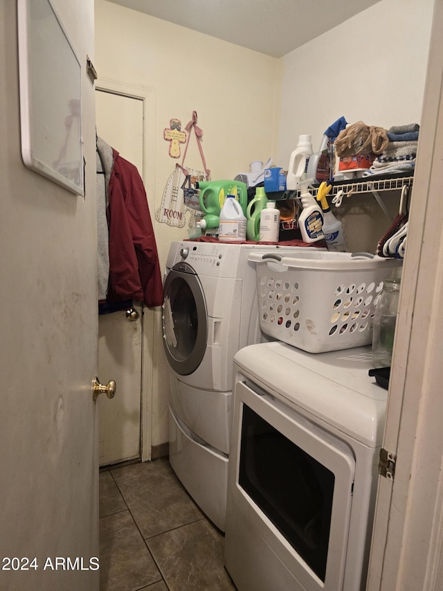 washroom featuring separate washer and dryer and dark tile patterned floors