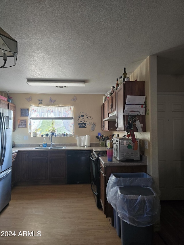 kitchen with black appliances, sink, light wood-type flooring, a textured ceiling, and dark brown cabinets