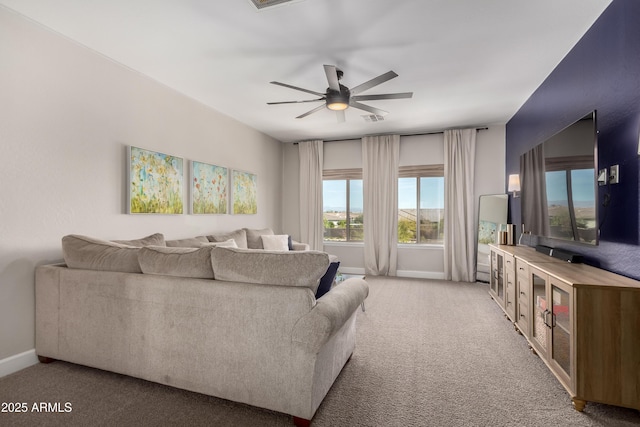 living area with light carpet, visible vents, a ceiling fan, and baseboards