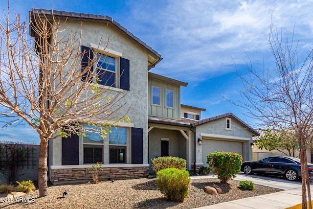 view of front of property with an attached garage, driveway, stone siding, stucco siding, and board and batten siding