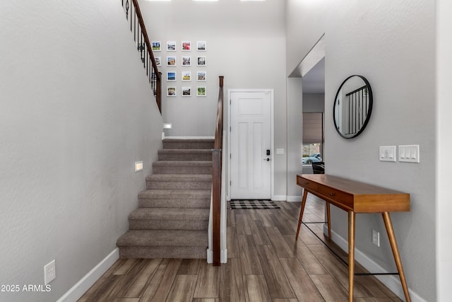 staircase featuring baseboards and wood finished floors