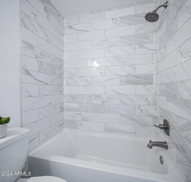 bathroom with tiled shower / bath combo and toilet