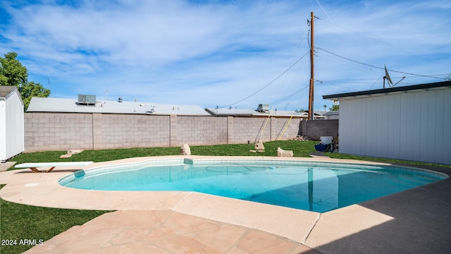 view of swimming pool featuring a diving board and a shed