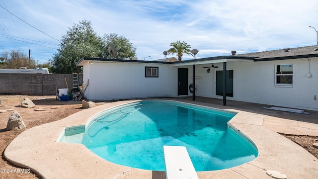 view of swimming pool featuring a diving board, a patio, and ceiling fan