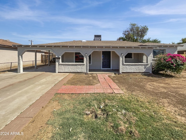 view of front of property with fence, concrete driveway, stucco siding, a porch, and roof with shingles