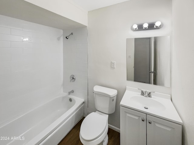 bathroom featuring toilet, vanity, wood finished floors, and bathing tub / shower combination