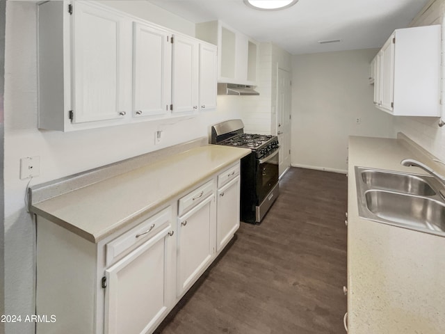 kitchen featuring white cabinets, a sink, gas range, light countertops, and under cabinet range hood