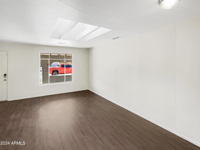 empty room with baseboards, wood finished floors, and visible vents