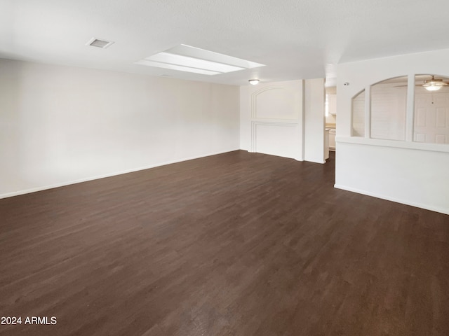 empty room with ceiling fan and dark wood-type flooring