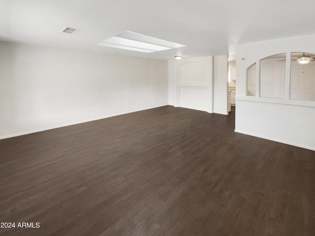 unfurnished room featuring baseboards, visible vents, and dark wood finished floors